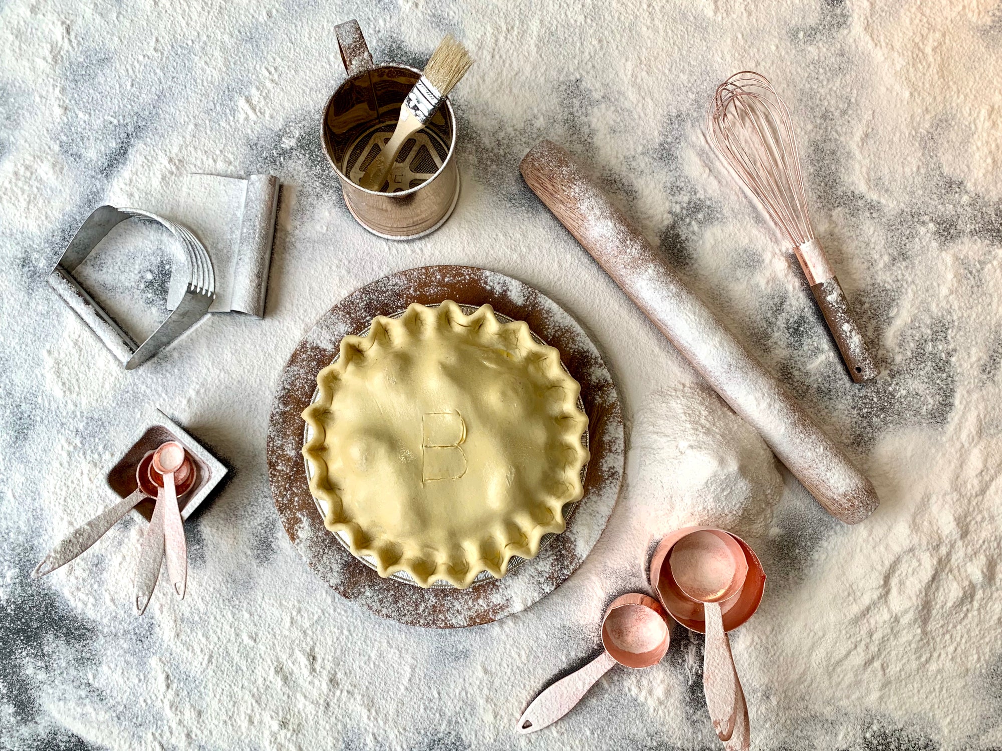 An image of an A La Mode pie on a countertop coated in flour. A behind the scenes view into our preperation process.