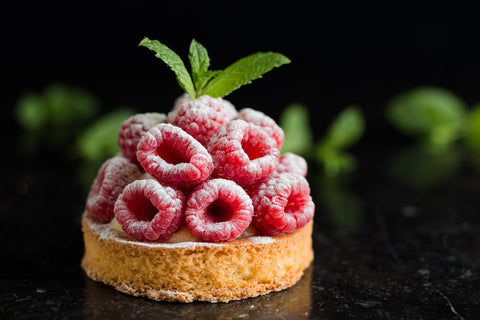 An image of A La Mode's raspberry tart set against a black background
